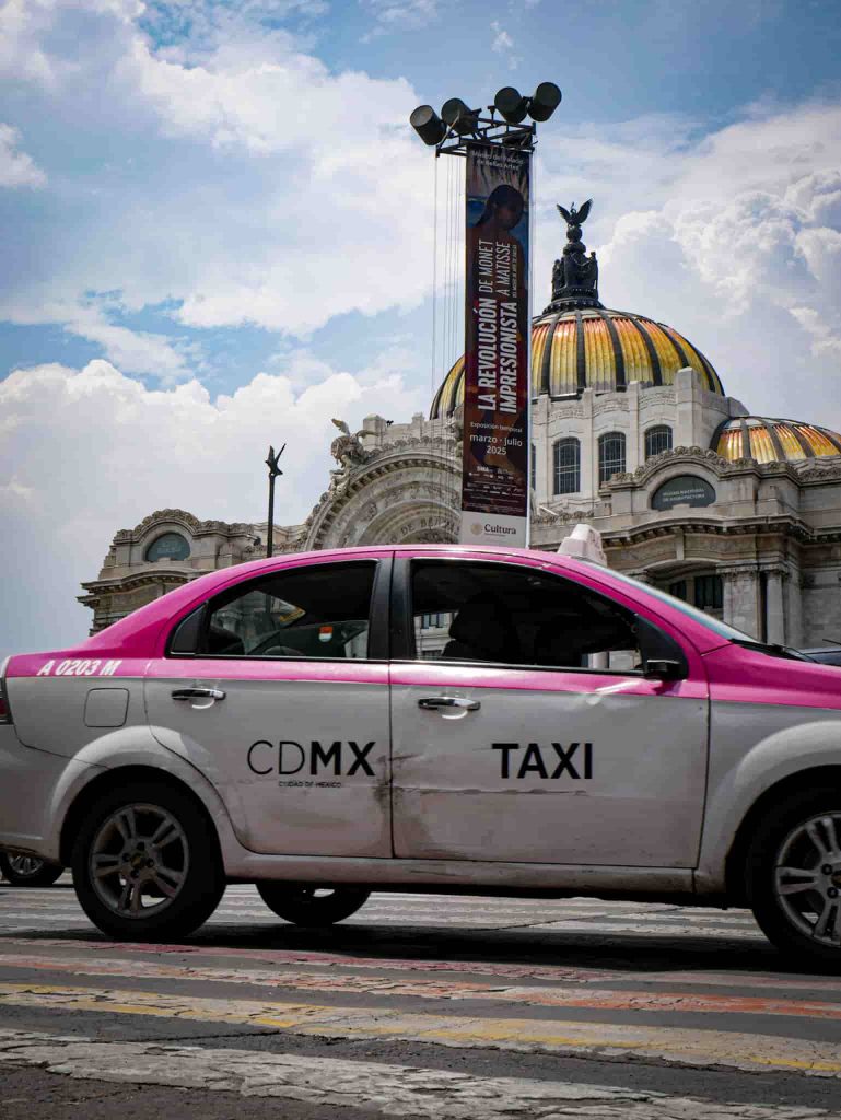 A pink and white official taxi of the Mexico City